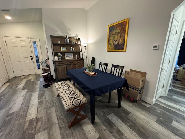 dining space featuring dark hardwood / wood-style floors and vaulted ceiling