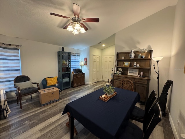 dining space featuring hardwood / wood-style flooring, lofted ceiling, and ceiling fan