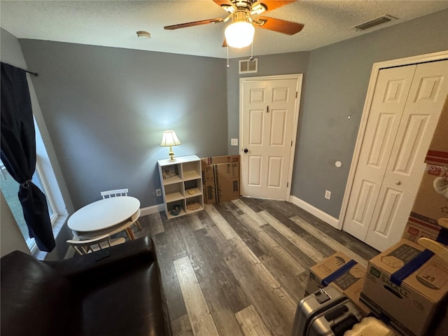 interior space featuring a textured ceiling, dark hardwood / wood-style floors, and ceiling fan