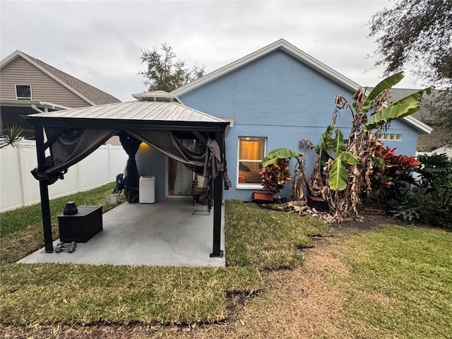 back of house featuring a patio and a lawn