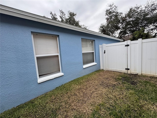 view of side of home with a yard