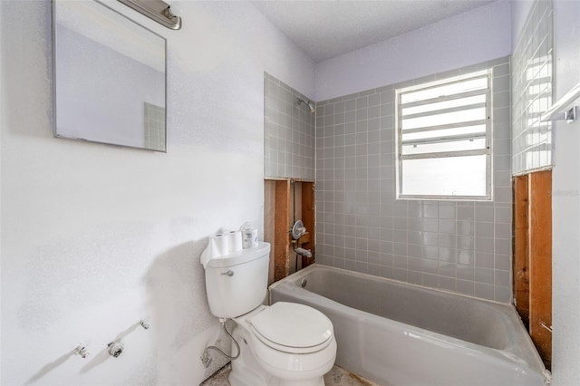 bathroom with tiled shower / bath and toilet