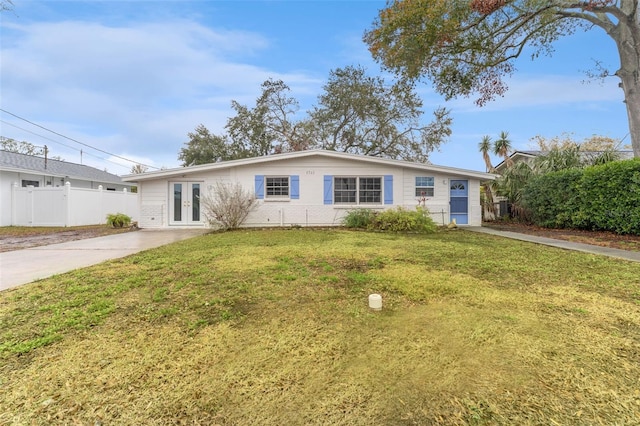 single story home with french doors and a front lawn