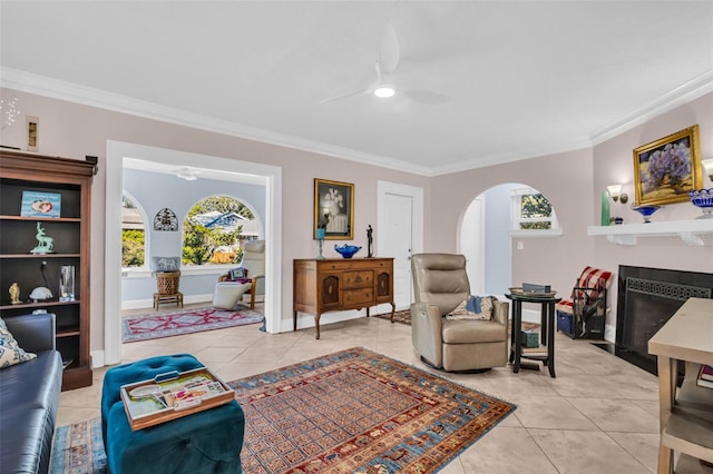 sitting room featuring tile patterned flooring, crown molding, a tile fireplace, and ceiling fan