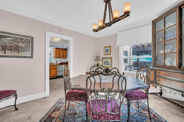 dining area featuring crown molding, light tile patterned floors, and a notable chandelier