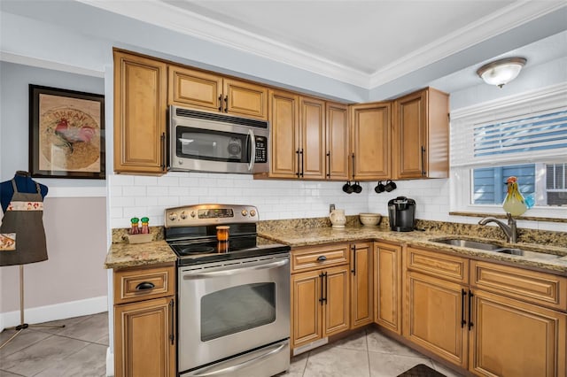 kitchen featuring appliances with stainless steel finishes, brown cabinets, a sink, and light stone counters