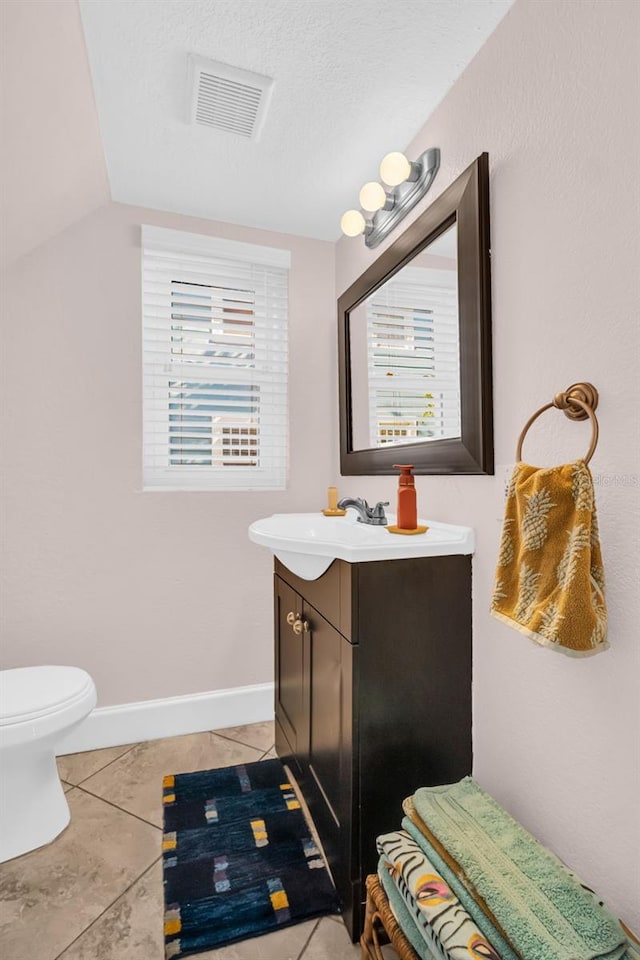 bathroom featuring vanity, tile patterned floors, a textured ceiling, and toilet