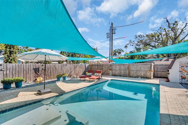 view of swimming pool featuring a fenced in pool, a fenced backyard, and a patio