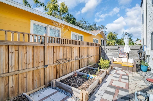 view of patio featuring fence and a vegetable garden