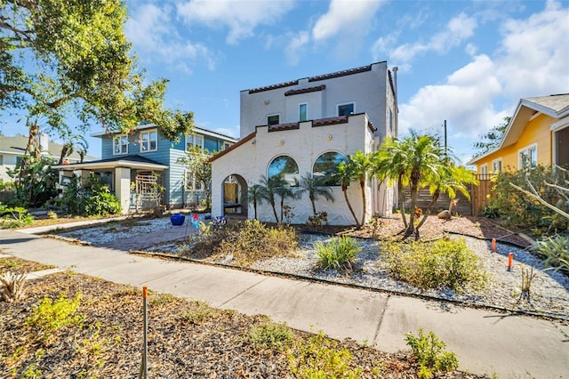 mediterranean / spanish-style home featuring fence and stucco siding