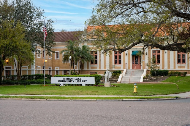 view of front facade with a front yard and a tile roof