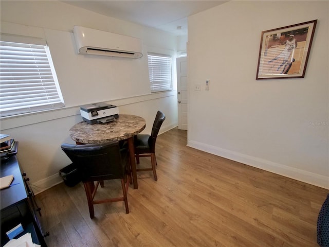 dining space with light hardwood / wood-style flooring and an AC wall unit