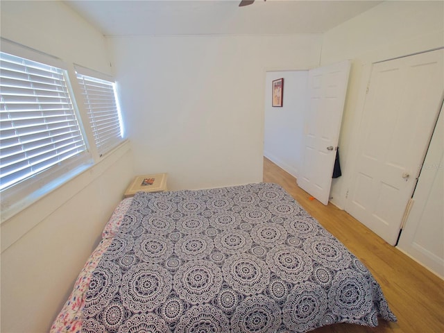 bedroom with light hardwood / wood-style floors, a closet, and ceiling fan