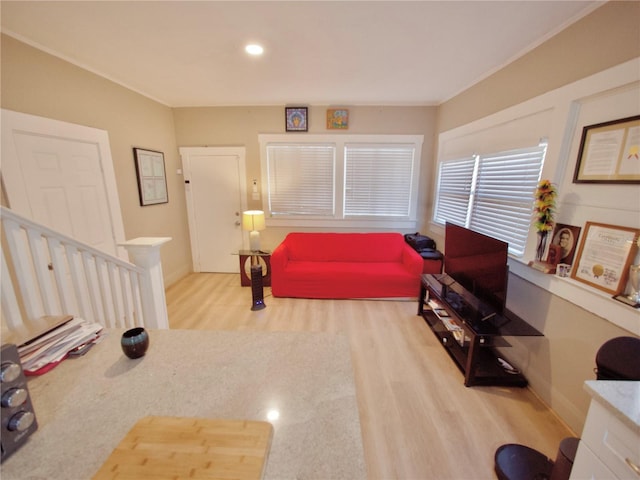 living room with ornamental molding and light hardwood / wood-style floors