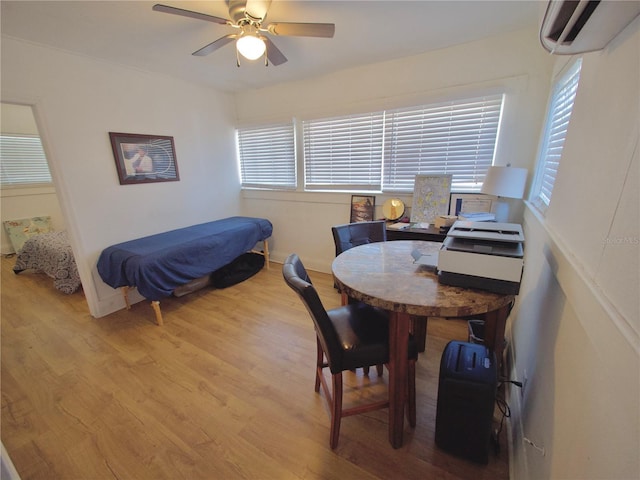 interior space featuring ceiling fan, a wall mounted AC, and light wood-type flooring