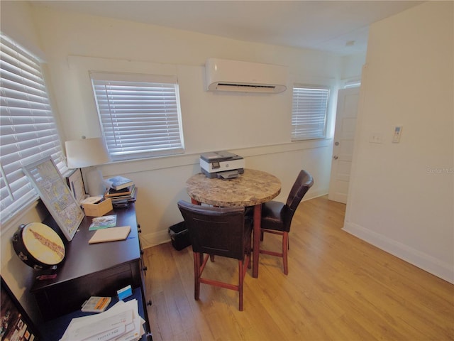 dining area featuring a wall mounted AC and light wood-type flooring