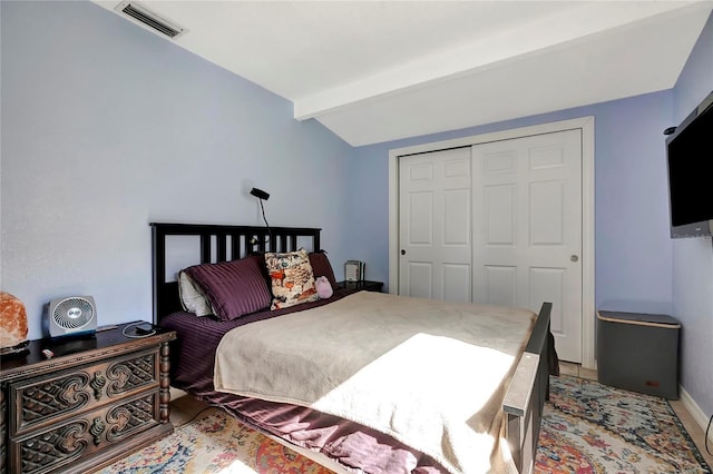 bedroom with vaulted ceiling with beams and a closet