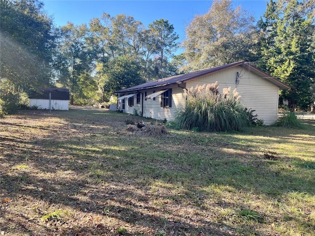 view of home's exterior with a yard and a shed