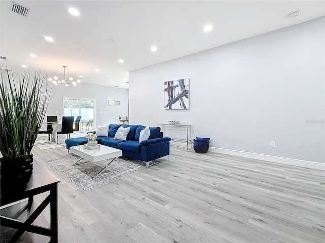 living room featuring light hardwood / wood-style flooring and a notable chandelier