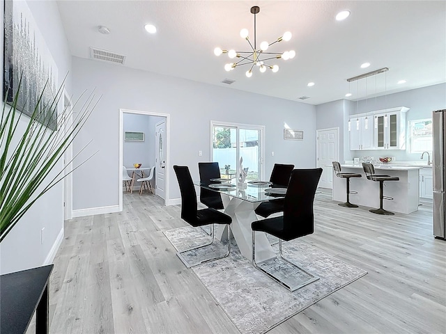 dining space featuring an inviting chandelier and light hardwood / wood-style flooring