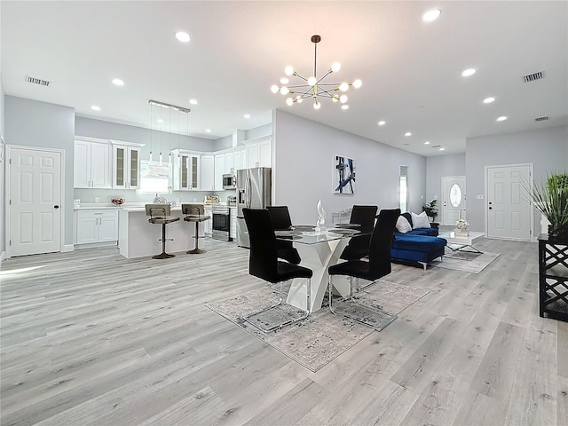 dining area featuring an inviting chandelier and light wood-type flooring