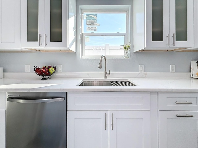 kitchen with light stone counters, dishwasher, sink, and white cabinets