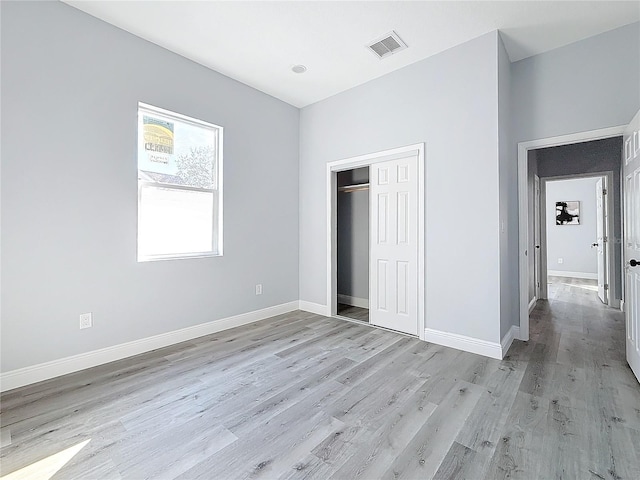 unfurnished bedroom with a closet and light hardwood / wood-style flooring