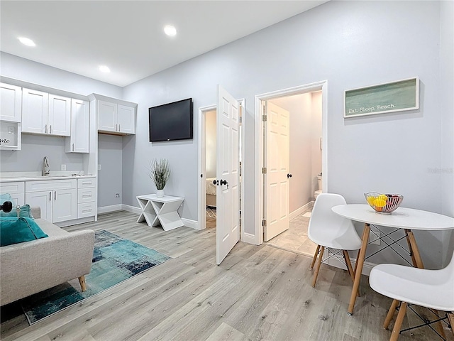 interior space featuring white cabinetry, sink, and light wood-type flooring