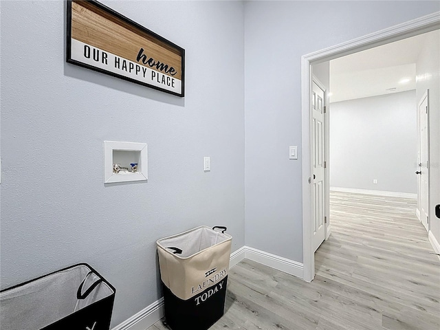 clothes washing area featuring hookup for a washing machine and light hardwood / wood-style floors