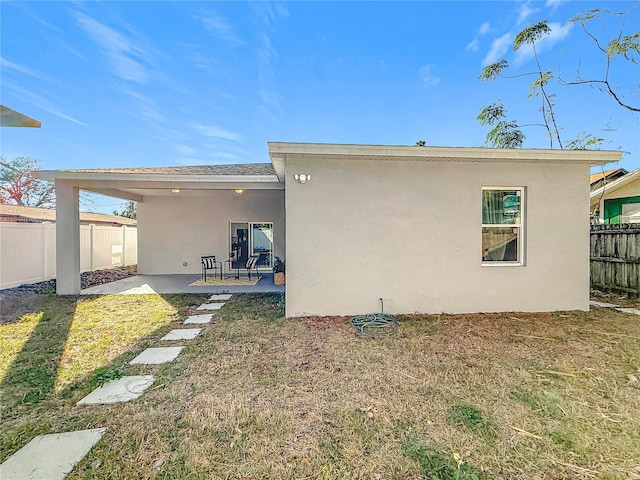 back of house featuring a yard and a patio area