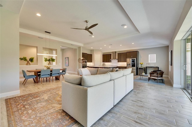 living room featuring crown molding, wine cooler, ceiling fan, and a tray ceiling