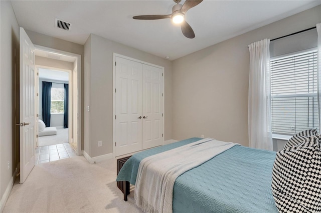 carpeted bedroom with ceiling fan and a closet