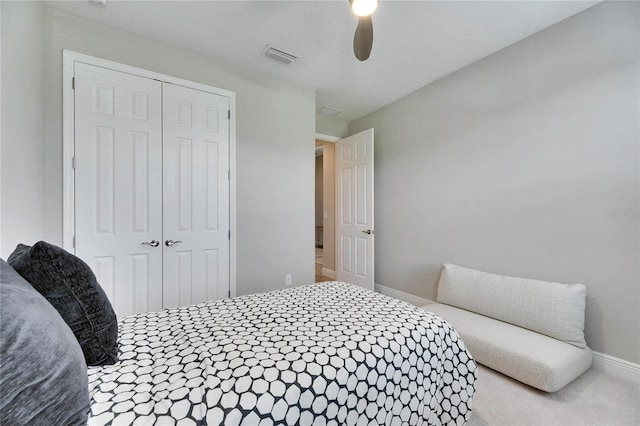 carpeted bedroom with ceiling fan and a closet