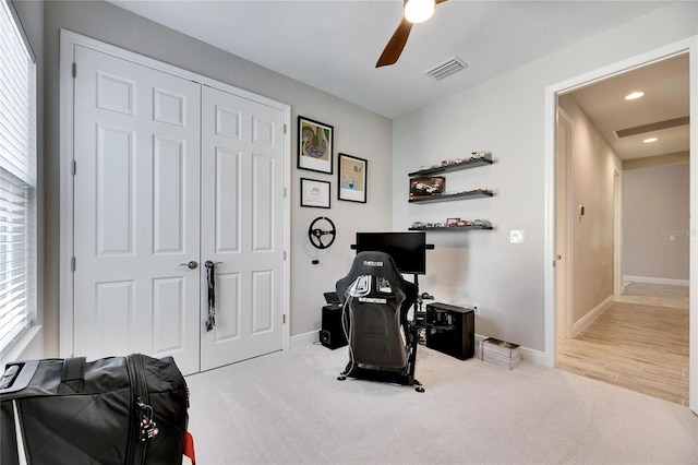 miscellaneous room with ceiling fan and light carpet