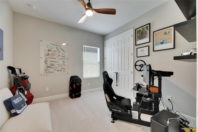 carpeted office space featuring ceiling fan