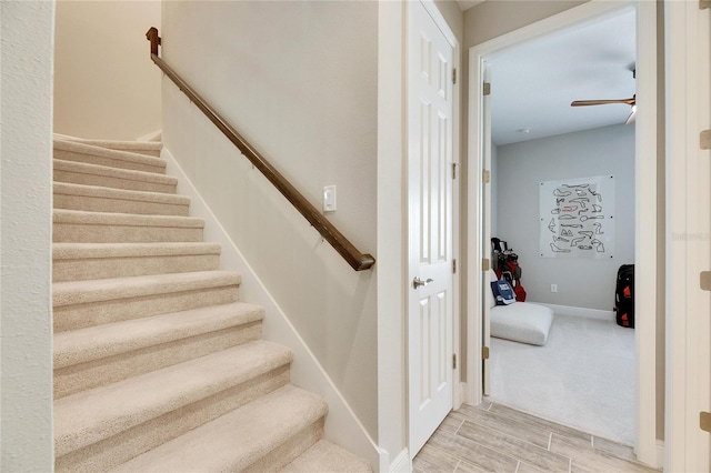 stairs featuring ceiling fan