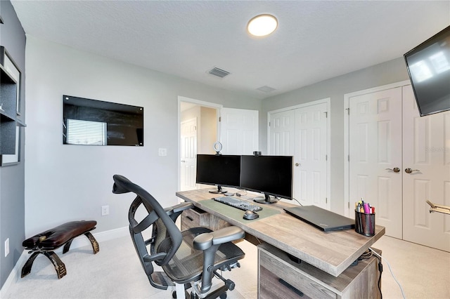 home office featuring light carpet and a textured ceiling