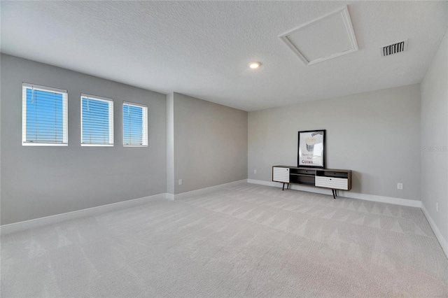 carpeted spare room with a textured ceiling