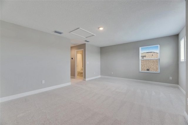 carpeted empty room with a textured ceiling