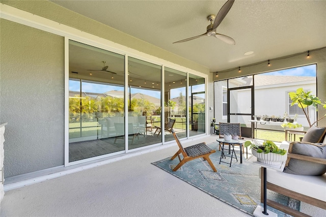 sunroom with a mountain view and ceiling fan