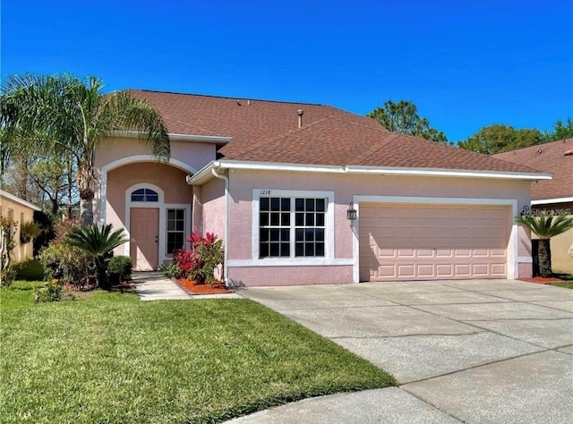 ranch-style home with a garage and a front lawn