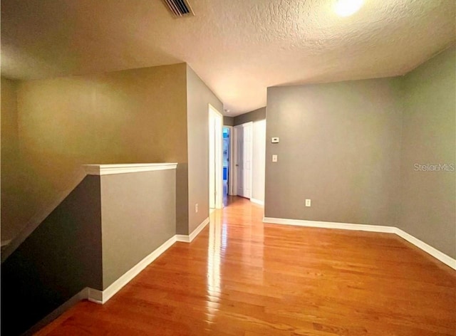 hall featuring hardwood / wood-style flooring and a textured ceiling