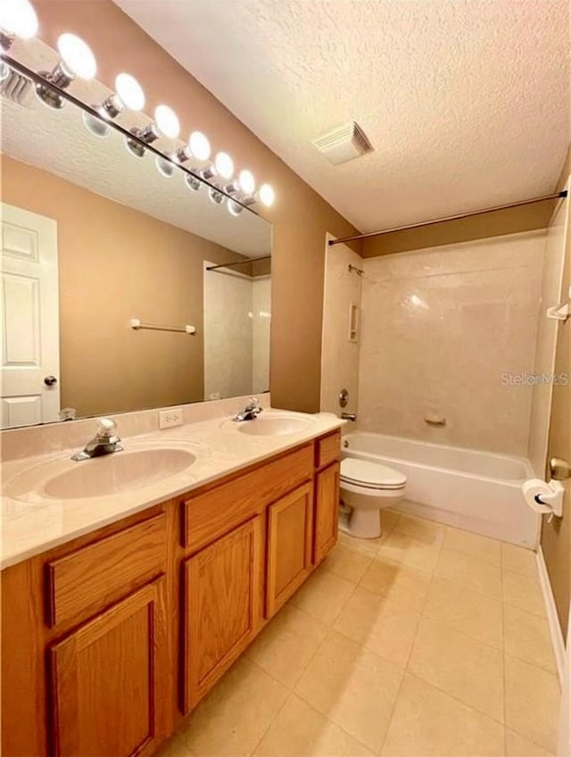 full bathroom featuring tile patterned floors, toilet, bathing tub / shower combination, a textured ceiling, and vanity