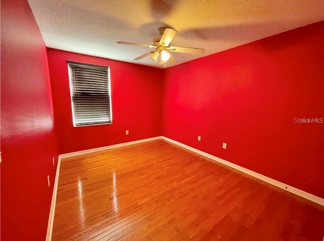 empty room featuring ceiling fan, hardwood / wood-style floors, and a textured ceiling