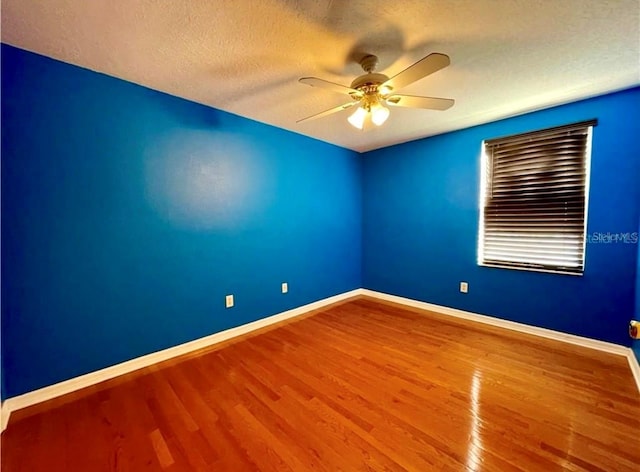 spare room featuring wood-type flooring, ceiling fan, and a textured ceiling