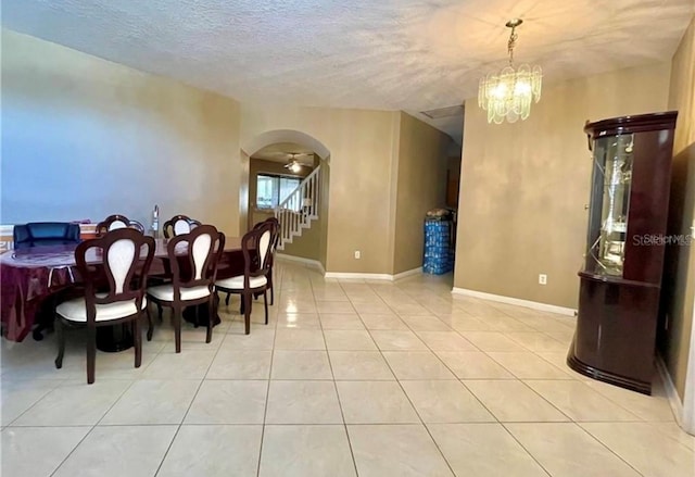 dining area featuring an inviting chandelier, a textured ceiling, and light tile patterned floors