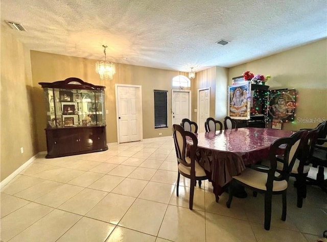 dining room with light tile patterned floors, a chandelier, and a textured ceiling