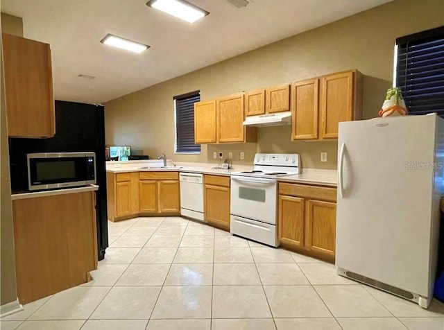 kitchen featuring white appliances, sink, and light tile patterned floors