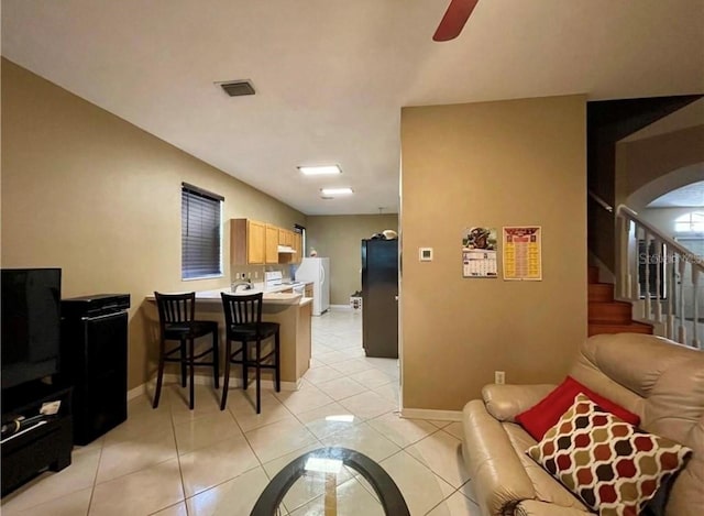 tiled living room with ceiling fan