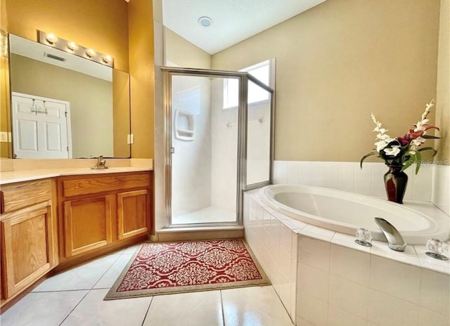 bathroom featuring independent shower and bath, vanity, vaulted ceiling, and tile patterned flooring